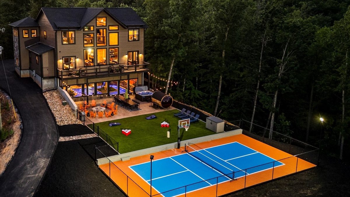 Twilight aerial of custom Gatlinburg lodge with private pickleball court, built by Cabins & Homes by Donnie Allen
